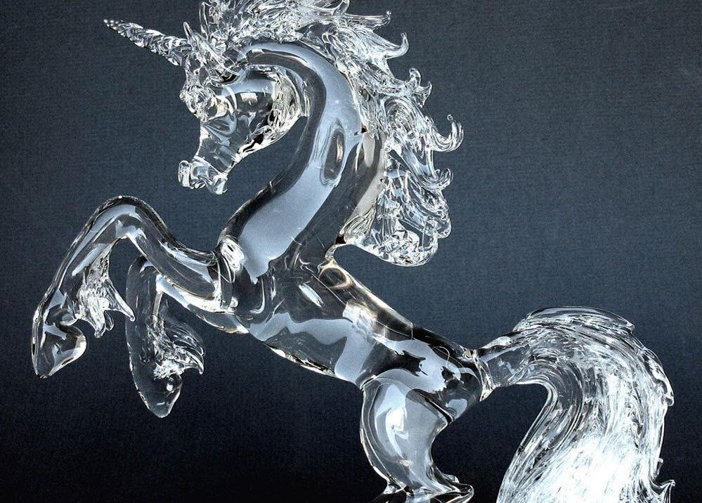Glass sculpture of a unicorn on its hind legs, ready to charge. 