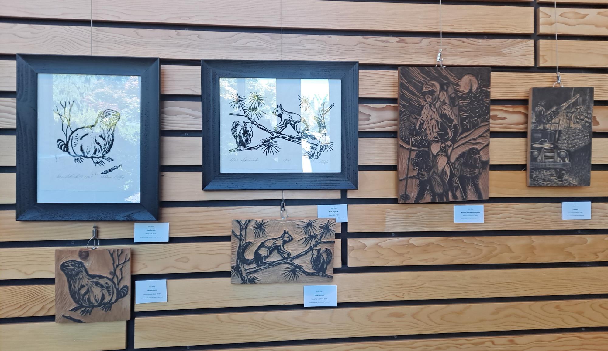 Several pieces of woodcut artwork of squirrels, beavers, and various wildlife displayed in City Hall.